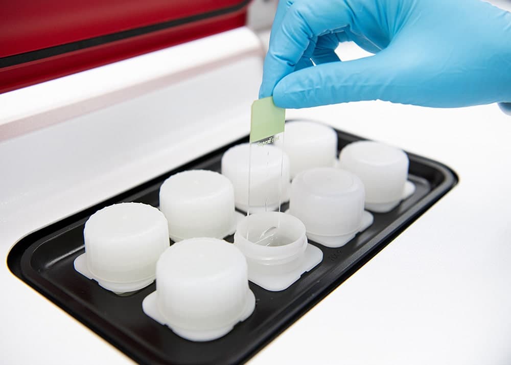 Staining reagent pots with a slide being loaded